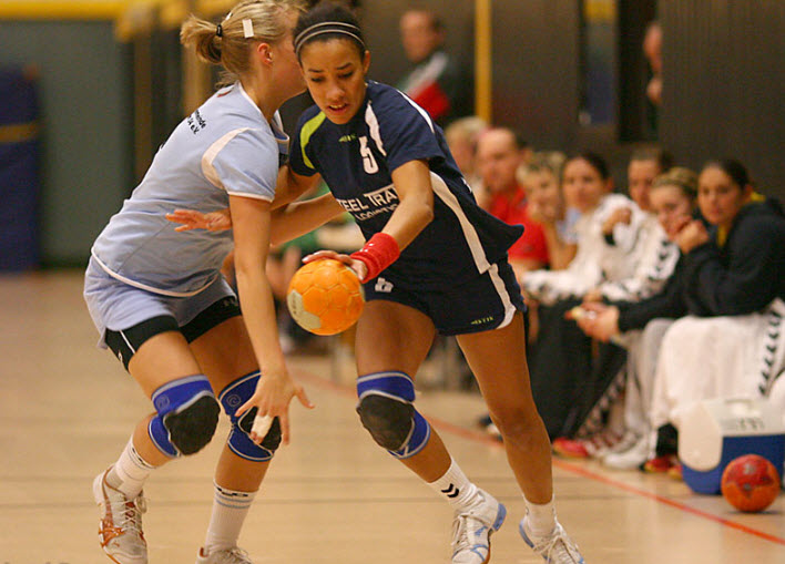 Eine Handballerin setzt sich gegen die gegnerische Abwehr durch